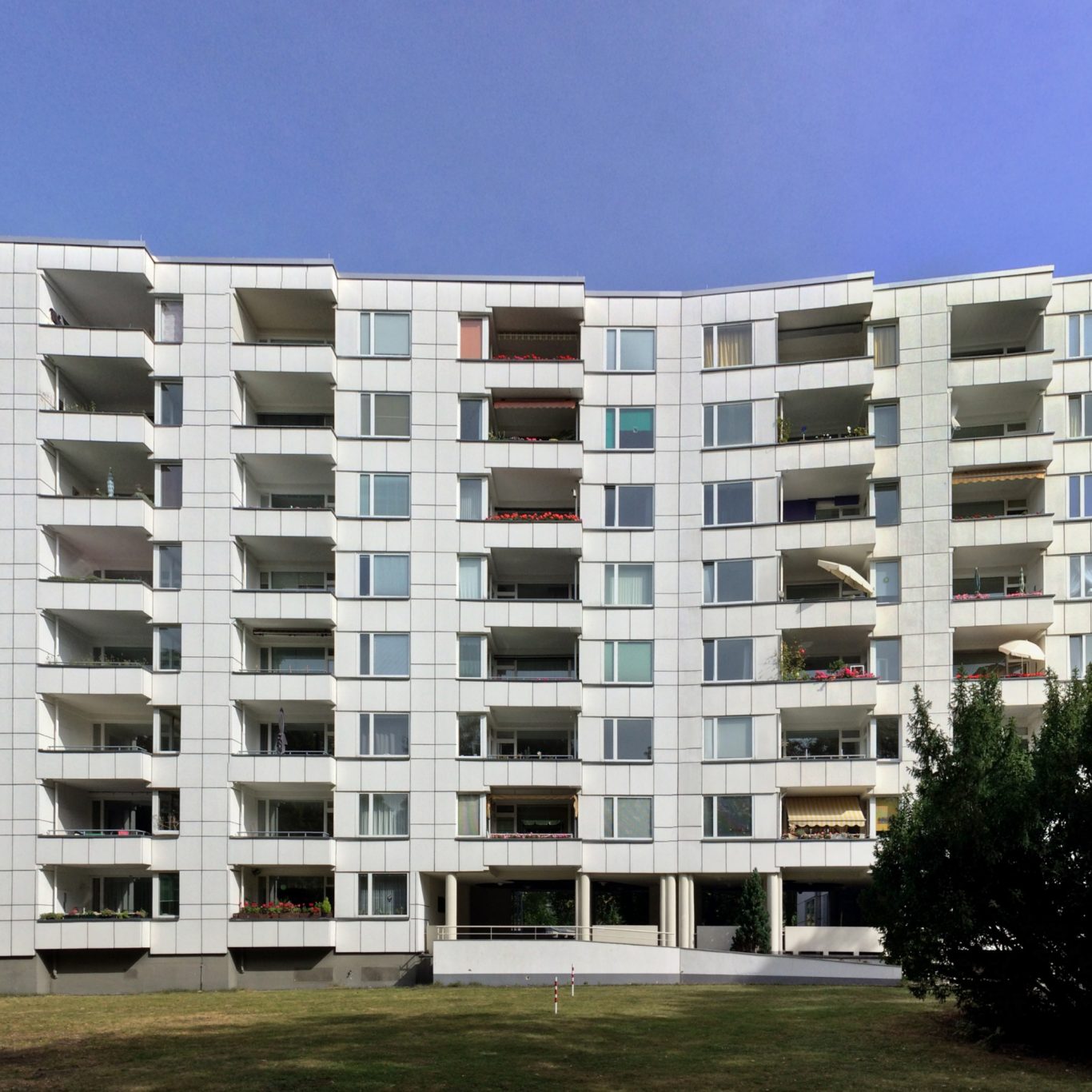 Wohnhaus im Hansaviertel in Berlin Moderne Wohnanlage mit mehreren Balkonen und großen Fensterfronten, umgeben von Rasen.